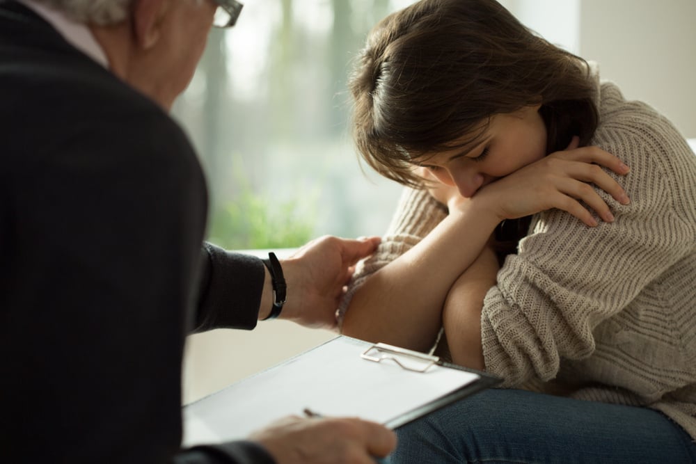 Close-up of psychologist comforting his depressed patient